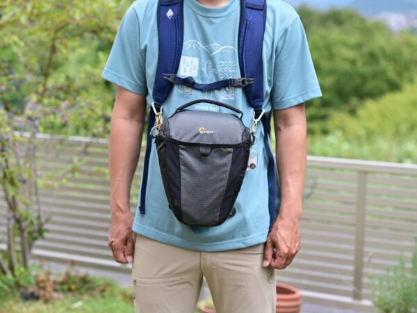 ザックのショルダーハーネスにカメラバッグを取り付けている画像