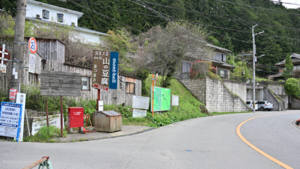 山の豆腐、モンベルの看板のある道の画像
